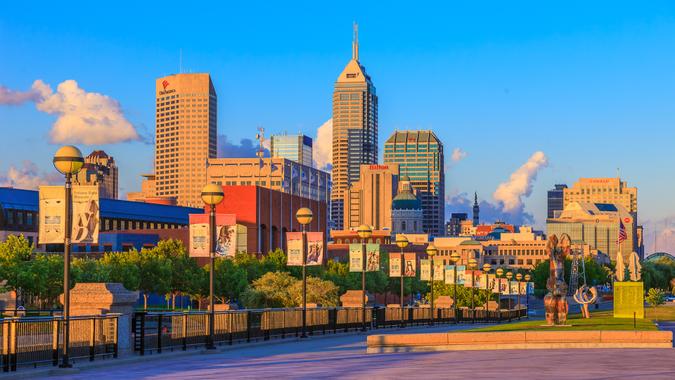 A walkway in White River State Park fills the foreground leading back to the main skyline of Indianapolis, Indiana.