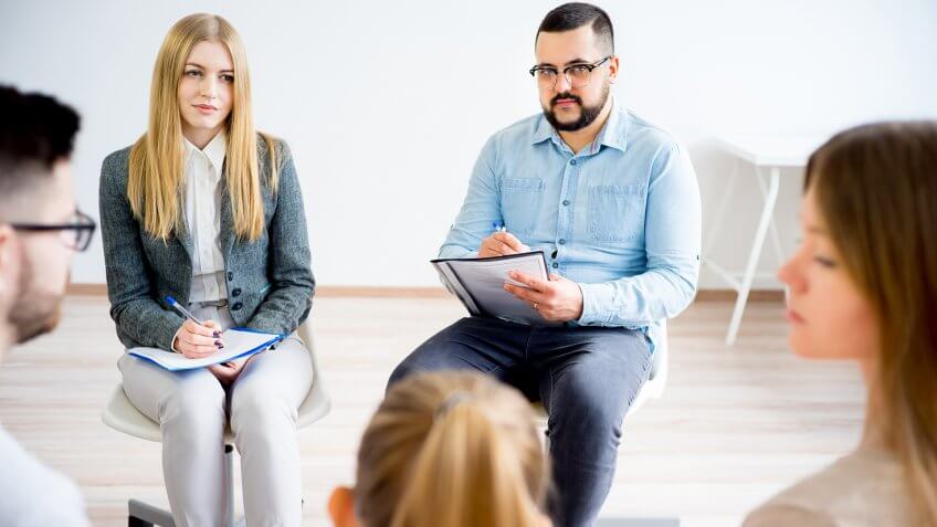 Psychiatrist and psychiatric technician taking notes listening to patients