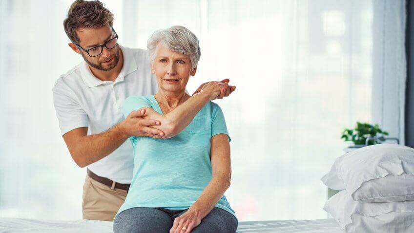 Exercise physiologist assisting senior woman with recovery