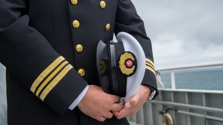 marine sailor holding his hat.