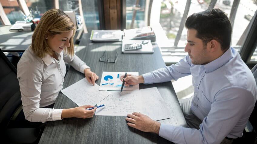 Successful business people working at the office and cheking statistics data on sales development.
