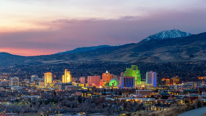 Reno at Dawn, Nevada Reno, Nevada,USA - November 26, 2017 : Reno downtown panorama with snow capped mountain in the background.