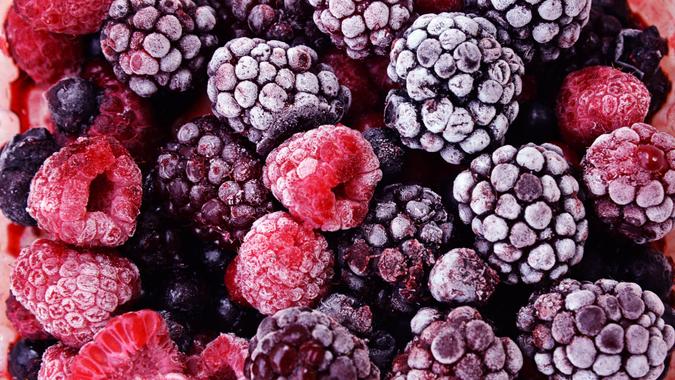Close up of frozen mixed fruit - berries - red currant, cranberry, raspberry, blackberry, bilberry, blueberry, black currant.