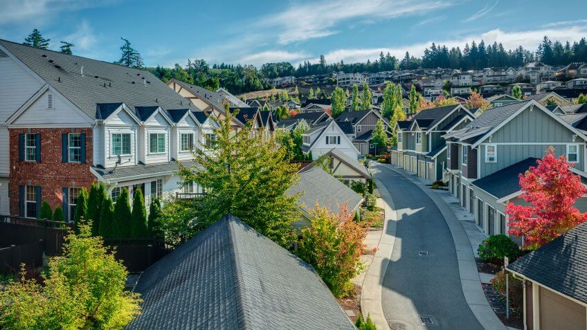 Houses line a Curvy Road that cuts through Residential Neighborhoods in the Issaquah Highlands on an Autumn Morning.