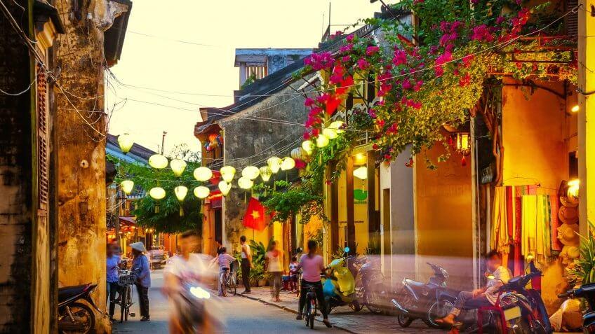 busy Street at duskSilk Lanterns in Hoi An an ancient city in Vietnampeople and scooter in motion blur.