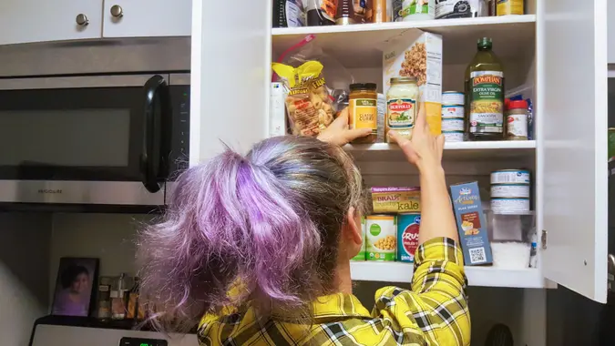 Woman grabbing jars from her pantry