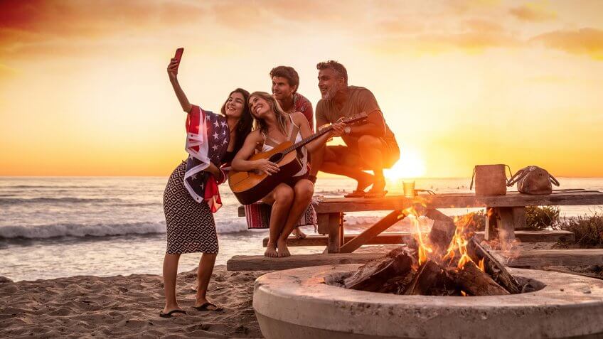Family party on the beach in California at sunset.