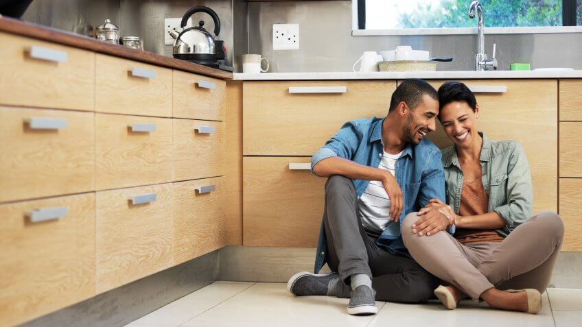 Shot of a smiling young couple sitting together on their kitchen floor.