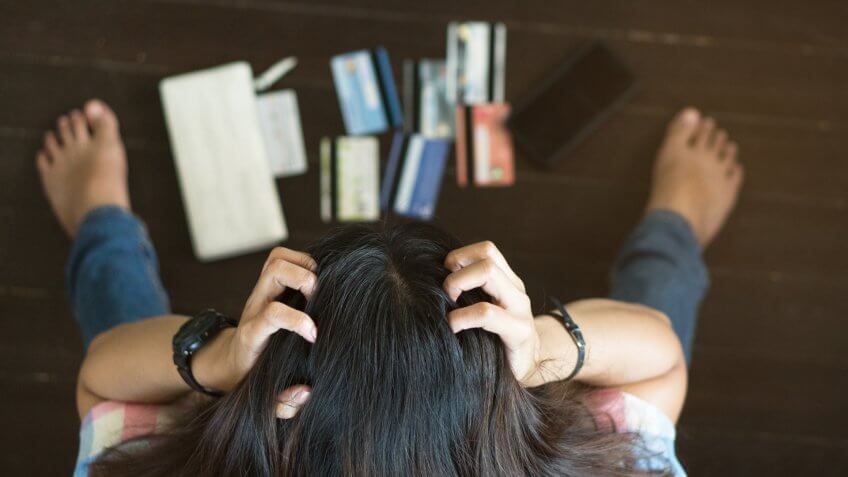 Top view of stressed woman trying to find money to pay credit card debt.