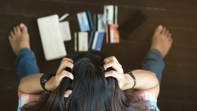 Top view of stressed woman trying to find money to pay credit card debt.