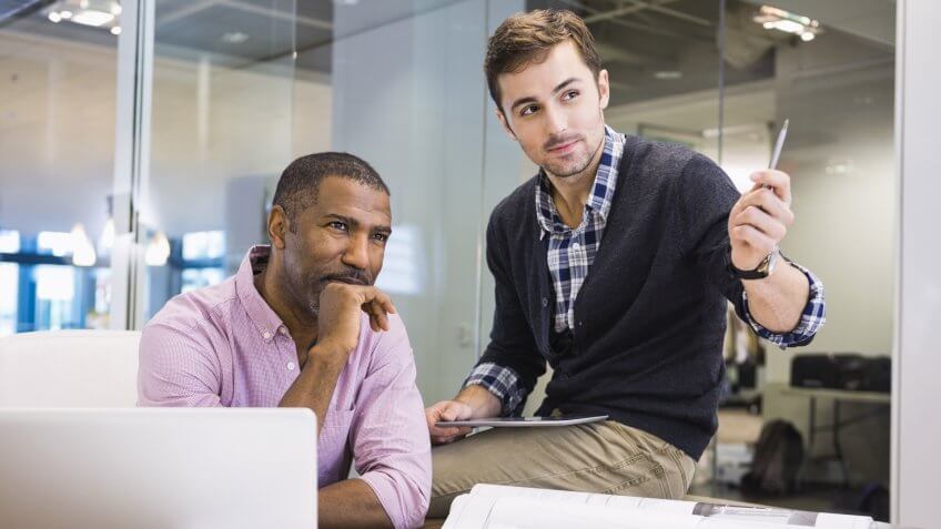 Businessmen looking away in conference room.