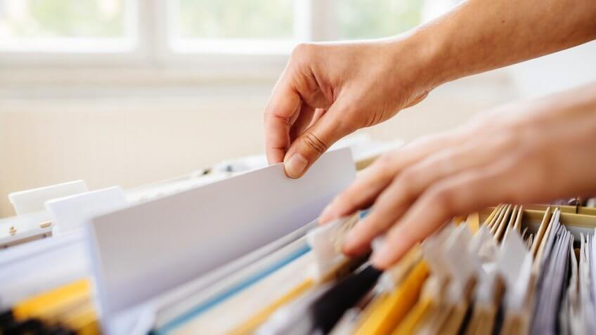 hand filing financial paperwork