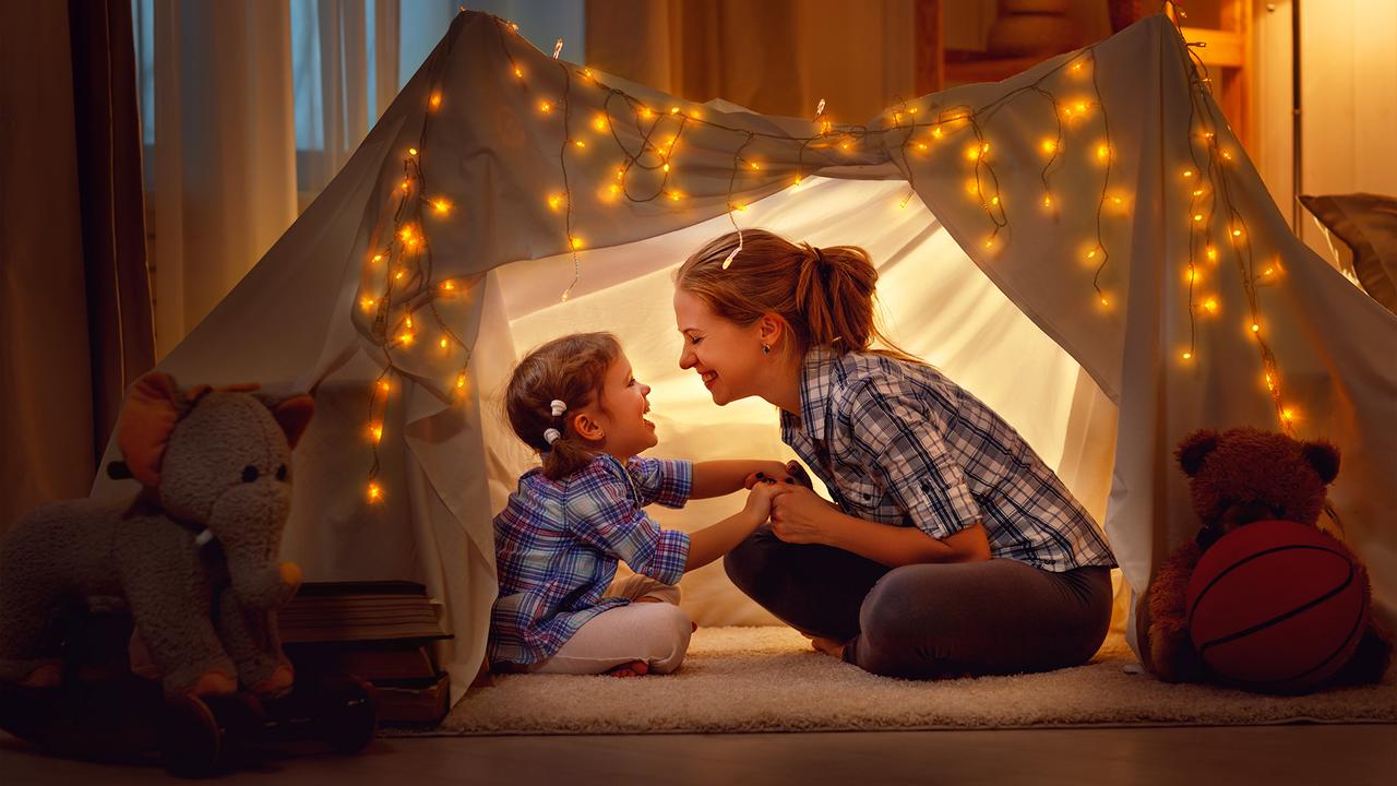 happy family mother and daughter playing at home in a tent.