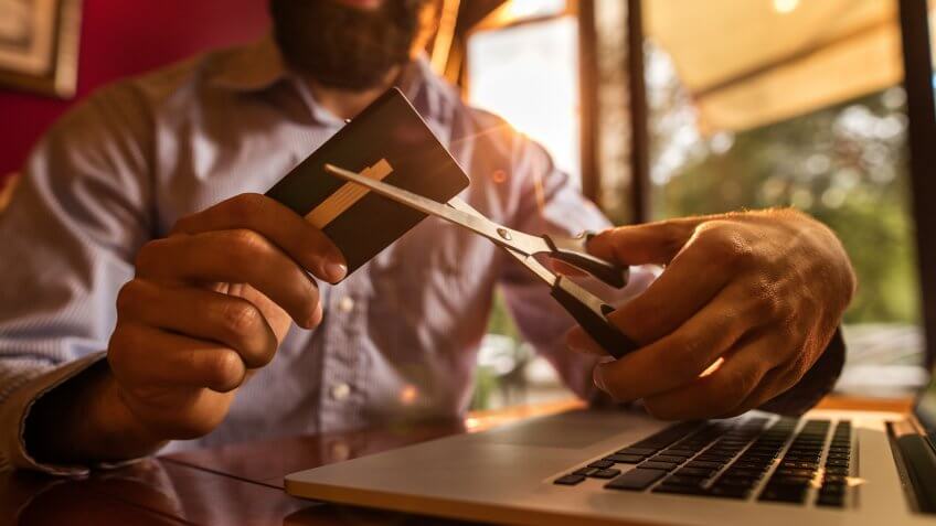 man cutting up credit card