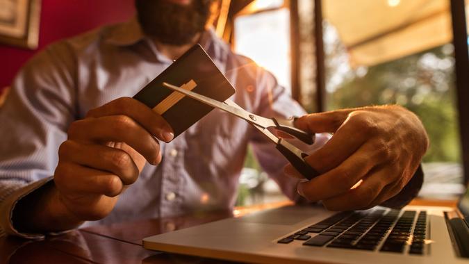 man cutting up credit card