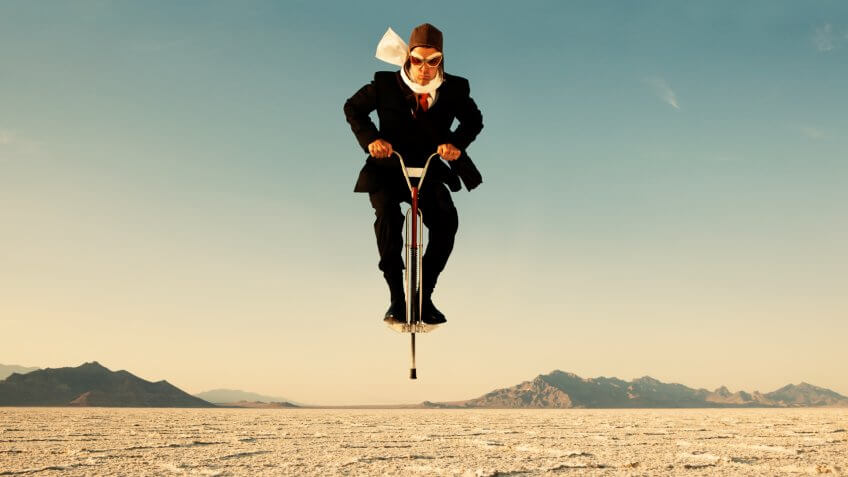 Businessman on Pogo Stick in Desert