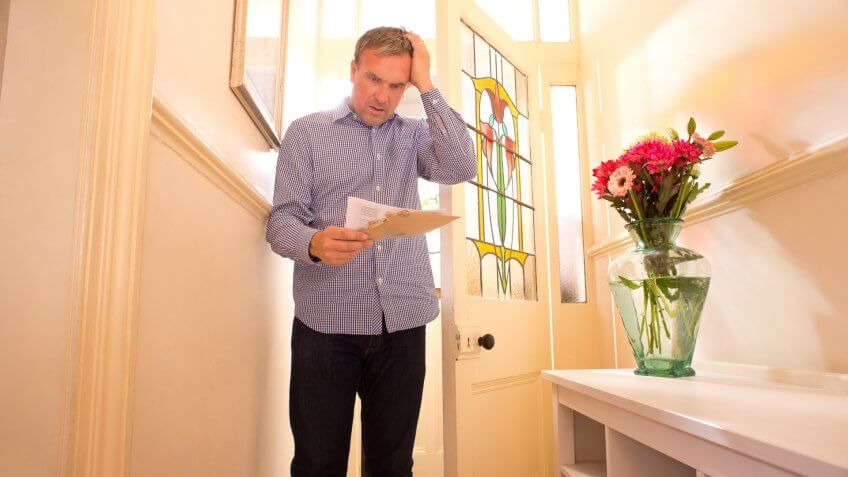 man receives bad news in the post.