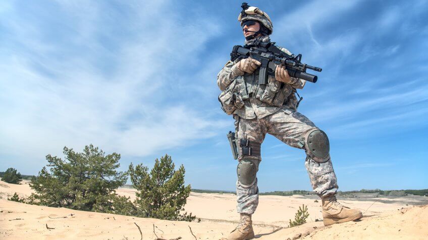 Portrait of United states airborne infantry corporal with arms, camo uniforms dress.