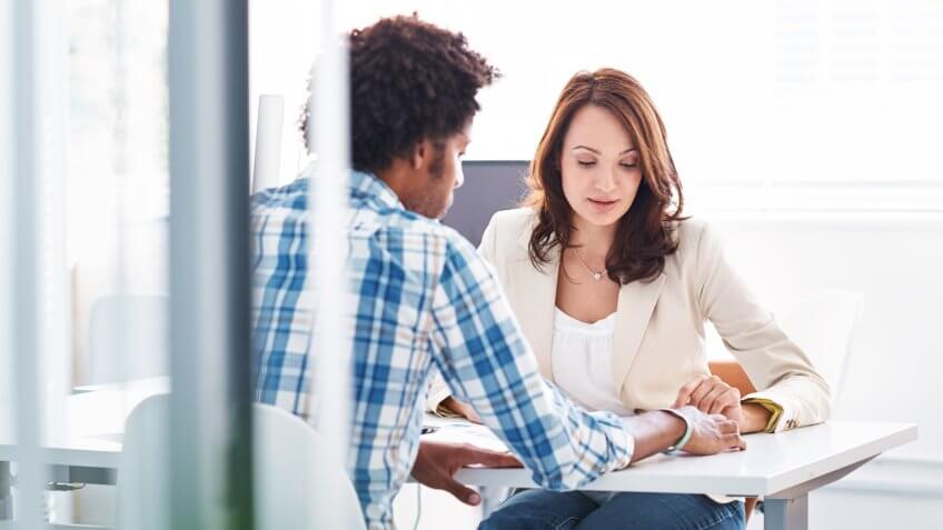 Shot of two young colleagues having a discussion in the boardroom.