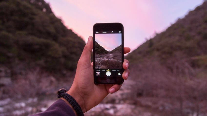 person taking photo with iPhone