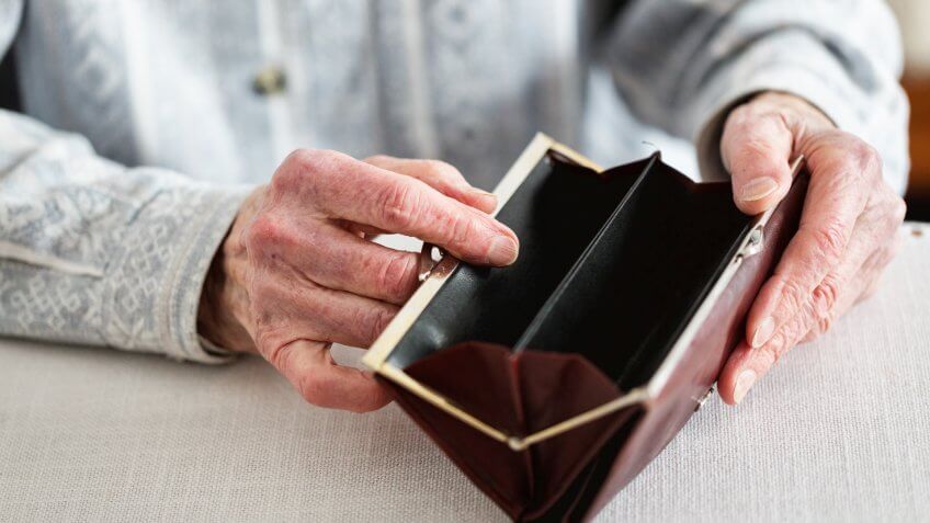Hands of senior woman, 90 years old, holding empty purse.