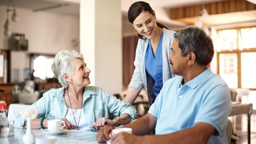 Shot of a young nurse caring for seniors residents in a retirement home.
