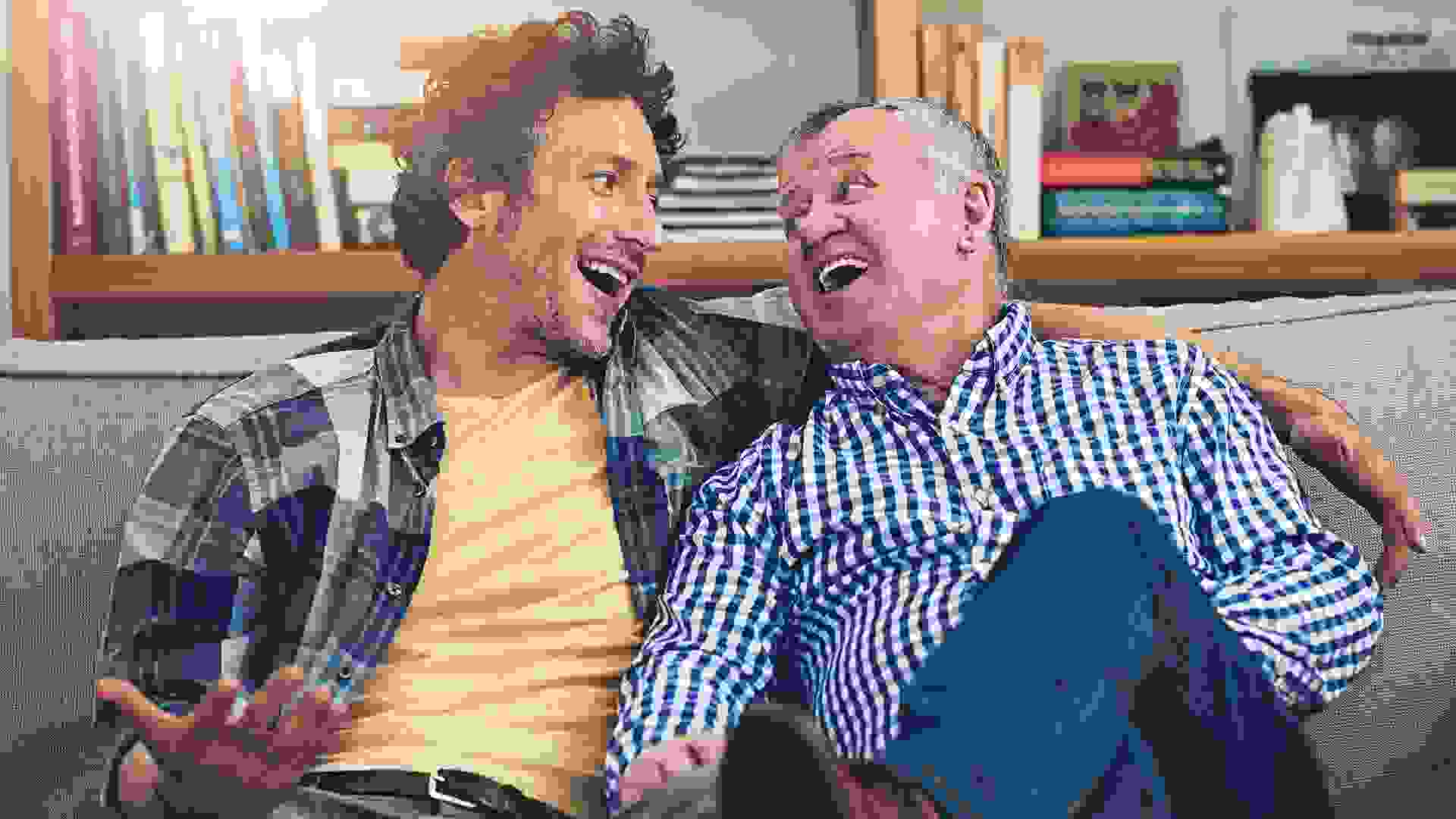 Shot of a mature man and his elderly father sitting on the sofa at home and having a chat.