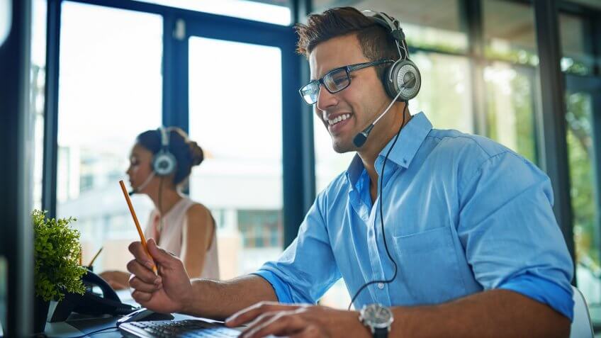 Shot of a young man working in a team of call center agents.
