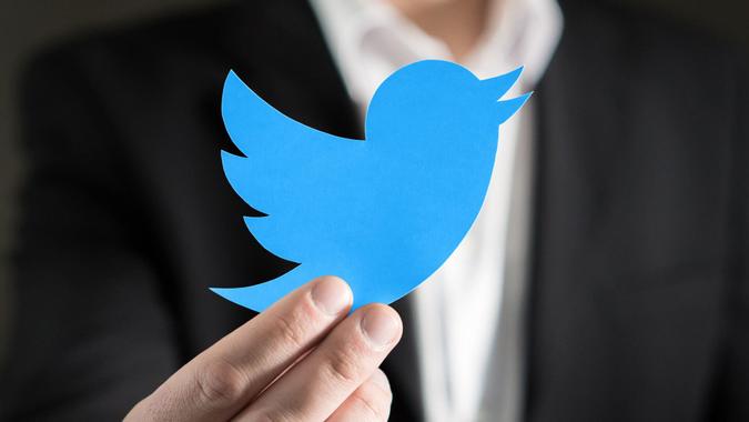 man holding twitter emblem