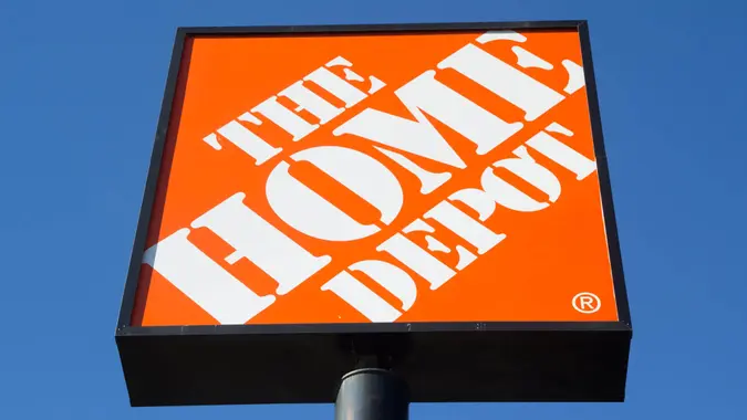 An orange and white Home Depot store sign amid blue skies.