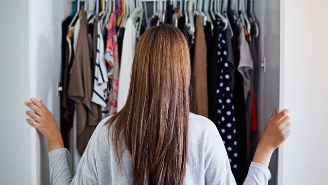 woman looking in unorganized closet woman looking in unorganized closet