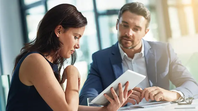 Shot of two businesspeople using a digital tablet together in an office.
