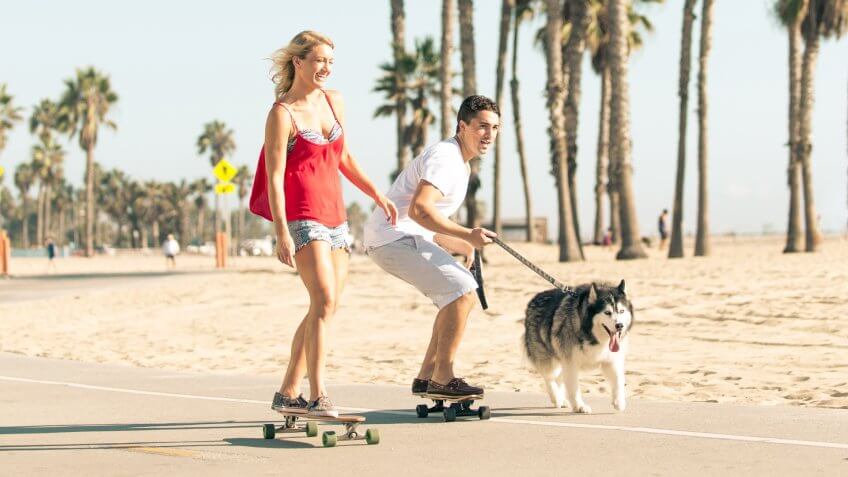 Happy couple making sport together with their husky dog.