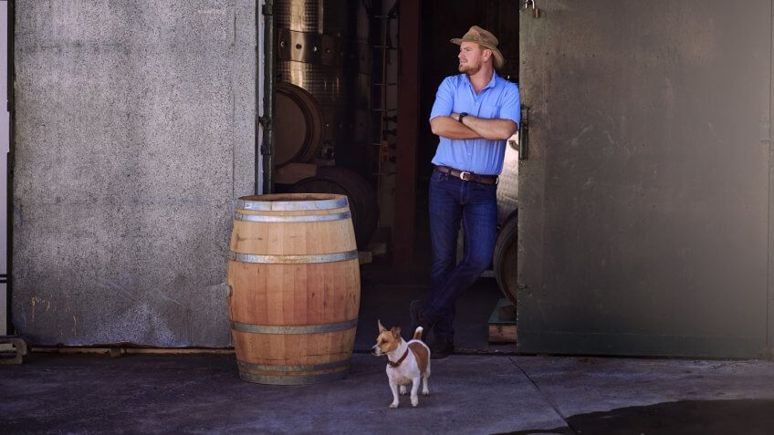 Shot of a male sommelier standing in the doorway of his distillery.