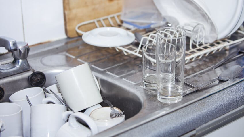 Office kitchen sink full of mugs to wash