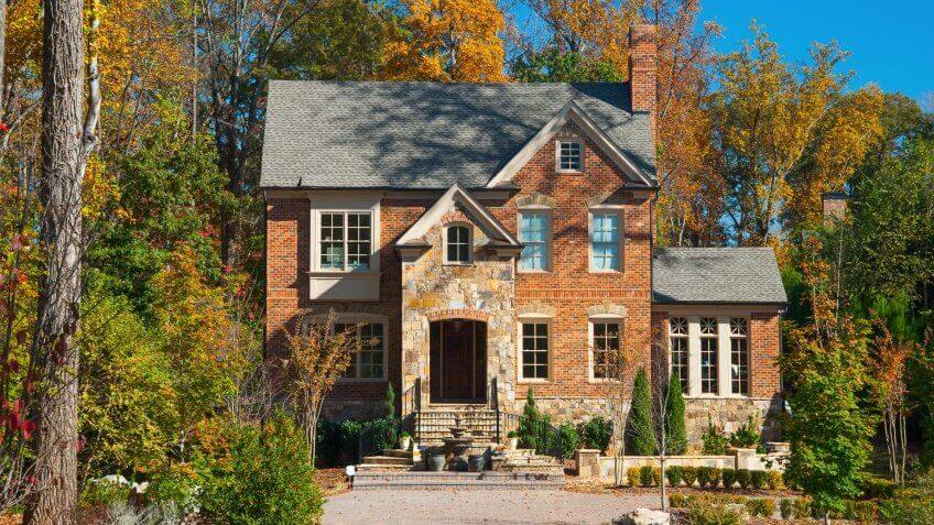 A brick house in the city of Atlanta, GA with a look like it's in the woods / a forest, characteristic of the look of northern Atlanta.