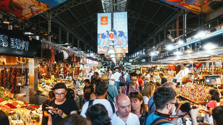 Barcelona, Spain - September 29, 2016: Tourists visiting the Boqueria Market, the most famous market in Barcelona.