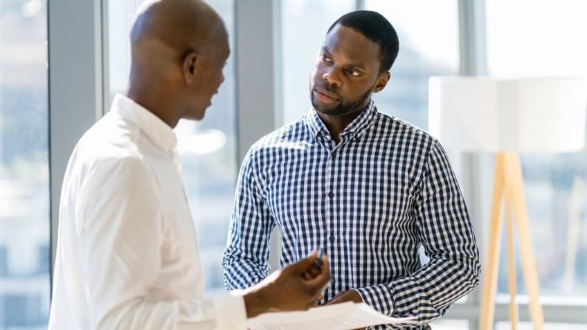 Mid adult businessman explaining strategy to young colleague.