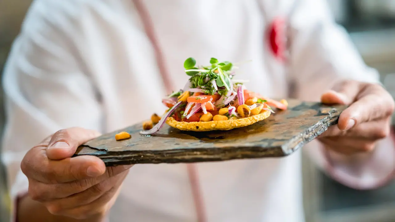 Close-up on a chef serving a small plate at a restaurant -? food and drinks concepts.