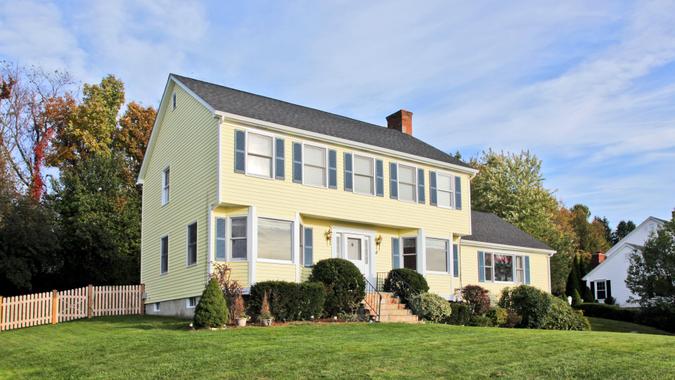 Yellow New England Style colonial house.