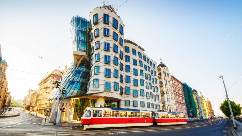 26 may 2018: Red tram passing in front of Dancing House building in Prague.