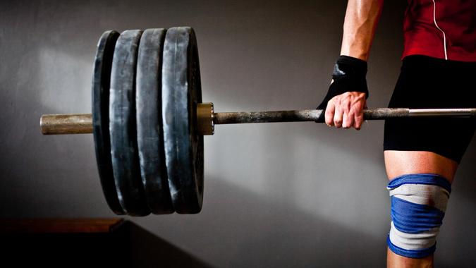 man lifting barbell and disks