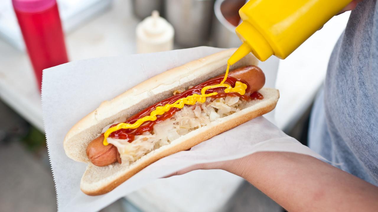 Putting mustard on a hot dog