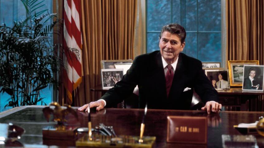 President Ronald Reagan at his desk in the Oval Office.