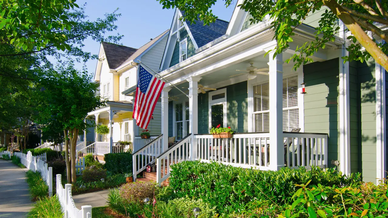Fort Mill, South Carolina, USA - June 6, 2014: The American Dream is pictured in this iconic image of a row of new, Victorian-style homes with a white picket fence in the Baxter Village neighborhood development located south of Charlotte, North Carolina.