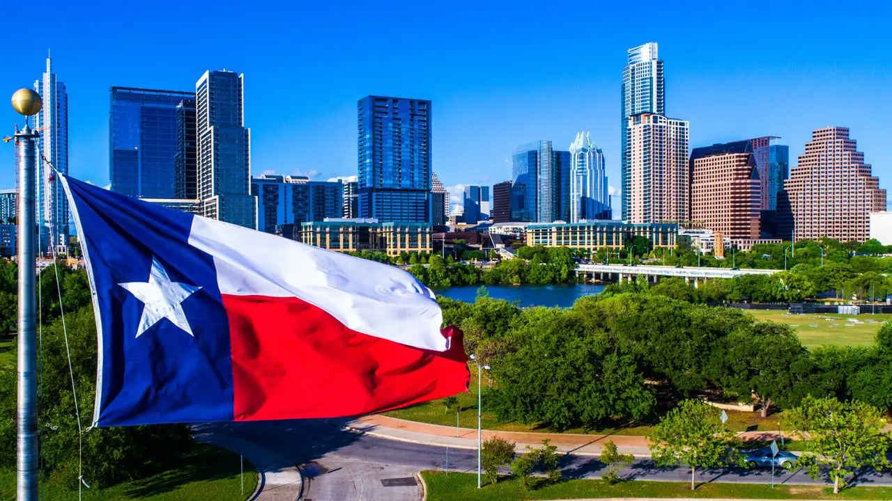 Aerial drone view Austin Texas Perfect Texas flag flying in front of Austin Texas downtown skyline cityscape sunny perfect day.