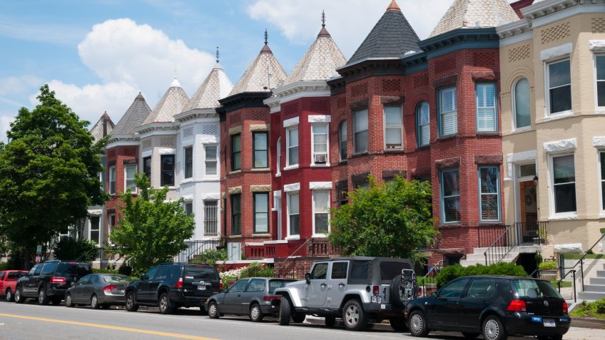 Cars are parked in front of rowhouses in a Washington DC neighborhood.