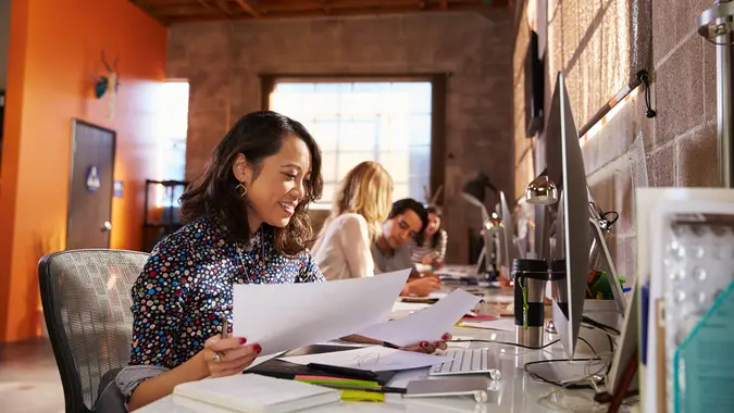 Team Of Designers Working At Desks In Modern Office.