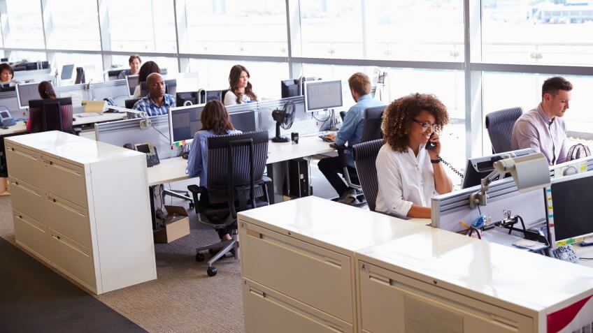 Casually dressed workers in a busy open plan office.