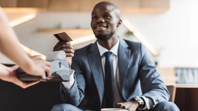 businessman paying with credit card in cafe.